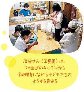 津守さん（写真奥）は、対面式のキッチンから調理をしながら子どもたちのようすを見守る